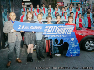 「ゴジラの真下」で27人の“冴羽リョウ”をバックに左からこだま監督、飯豊さん、神谷さん、伊倉さん、一龍齋さん、小山さん。